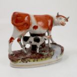 A 19th century Staffordshire model of a cow and calf standing by water, height 7.