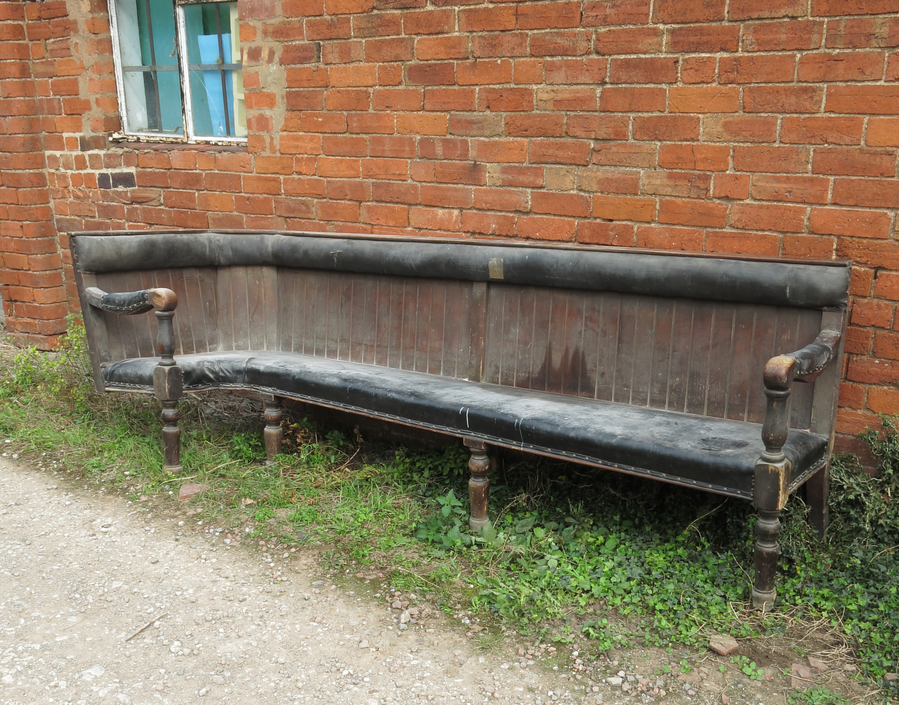 A section of 19th century corner club bench seating, with a tongue and groove back,