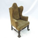 A 17th century style high wing backed armchair,