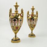 A pair of Royal Crown Derby porcelain covered pedestal vases, decorated in the Imari pattern,
