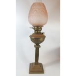 A Brass Oil Lamp with moulded pink glass shade