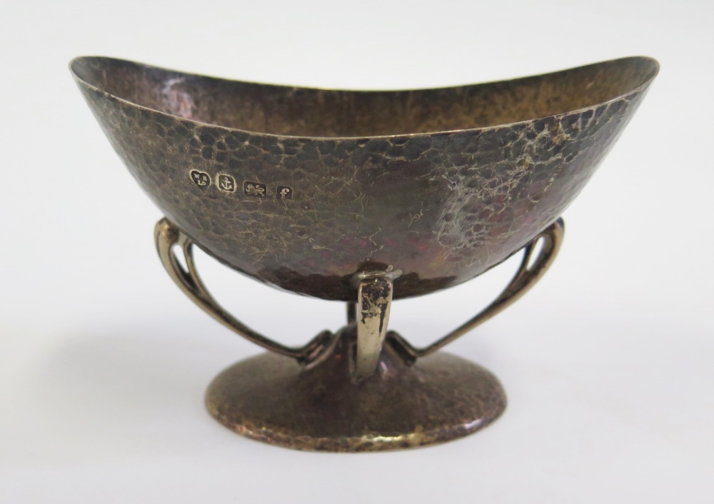 An Edward VII Arts & Crafts Silver Oval Bowl with planished decoration and raised on four c-scroll