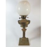 A Brass Oil Lamp with opaque glass shade