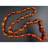 A Red Amber Bead Necklace containing various insect specimens, 154.5g and loose bead