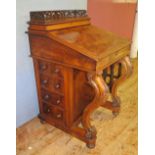 A Victorian Burr Walnut Davenport raised on carved s-scroll supports