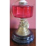 A Victorian Cranberry Glass and Brass Paraffin Lamp