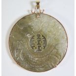 A Chinese Carved Jade Roundel Pendant decorated with dragon and phoenix and mounted in 9ct gold