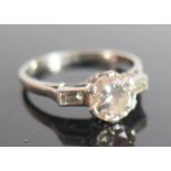 A Platinum and Diamond Solitaire Ring with baguette cut diamonds to the shoulders Sold with