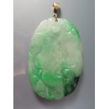 A Carved Jade Pendant decorated with trees and blossom, 9ct gold mount, 69mm