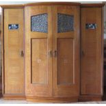 A Liberty Oak and Inlaid Triple Wardrobe, the central section with pierced and planished floral