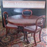 A Victorian Mahogany Circular Pedestal Table with carved lion paw feet and three chairs