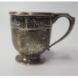 A George V Silver Christening Mug, the rim decorated with scenes of a man being chased by crocodile,