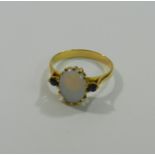 A yellow metal opal and sapphire three stone ring,