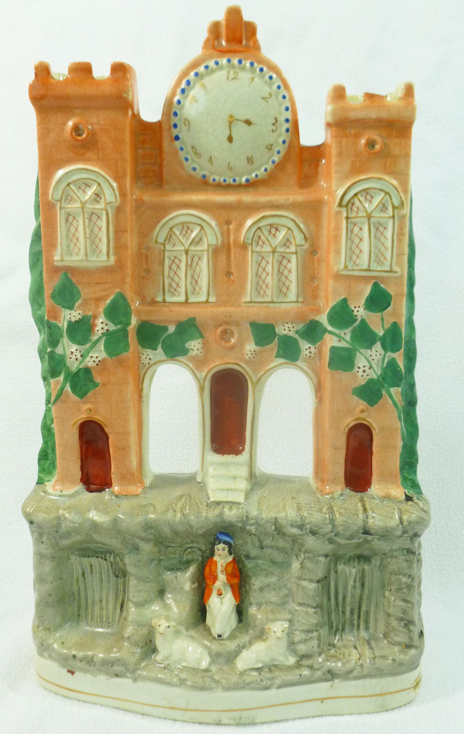 A Victorian Staffordshire pottery flatback in the form of a clock tower above a girl seated with a