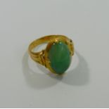 A Chinese gold jadeite set ring, the oval jadeite cabochon 13mm x 8mm in four claw setting,