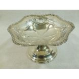 An Edwardian silver bon bon dish with formal embossed pierced and cast decoration on pedestal foot,