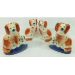 Three pairs of Staffordshire pottery spaniels, the largest with black markings and yellow eyes,