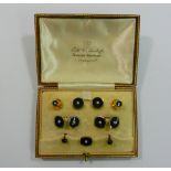 An early 20th century 18 carat white gold, 9 carat yellow gold, onyx and seed pearl dress stud,