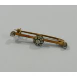 A Victorian diamond set gold bar brooch with central circular diamond cluster and diamond set