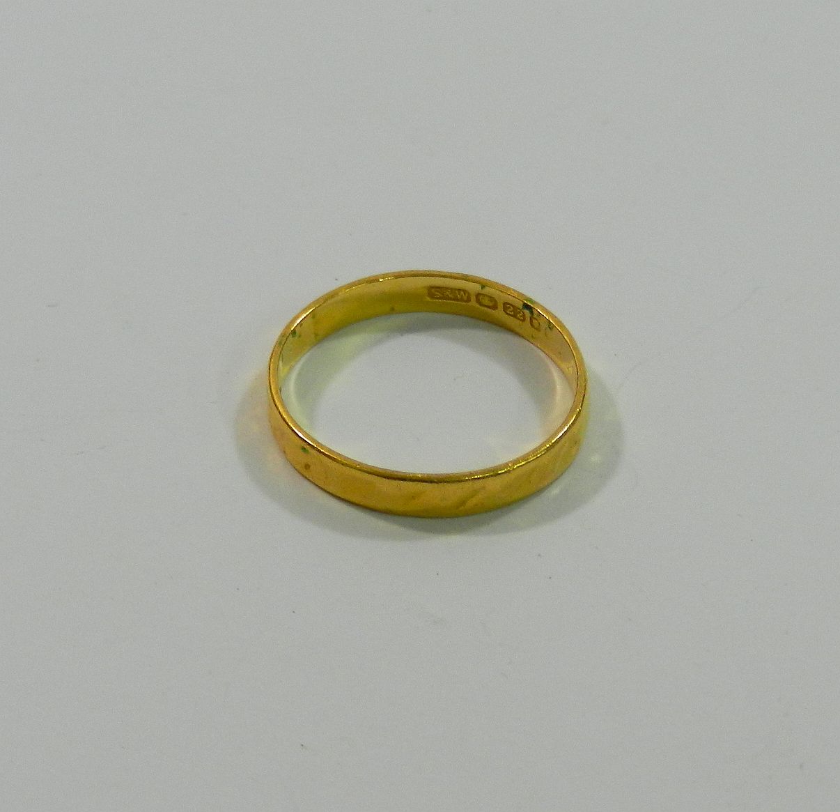 A 22 carat gold wedding band, hallmarks rubbed, possibly London 1972, 2.