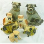 Two pairs of pottery pug dogs, the largest with brown glass eyes, 30cm high,