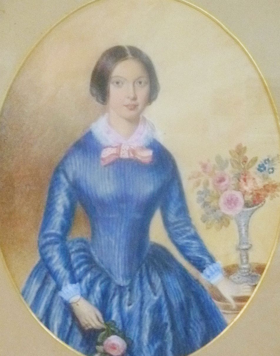 A Victorian watercolour portrait of a young woman in a blue dress beside a vase of flowers,