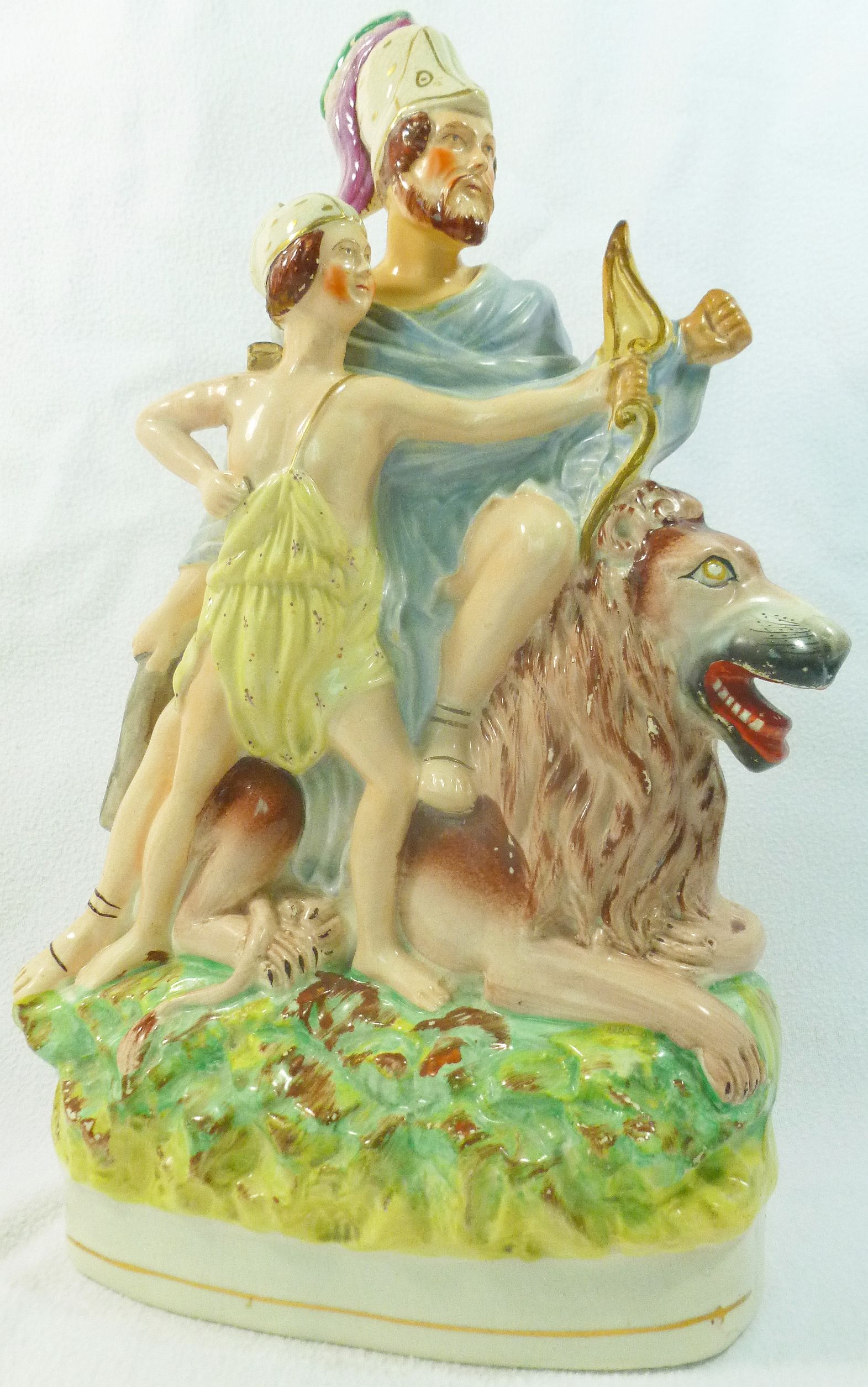 A Staffordshire pottery flatback group of a seated lion with a Greek warrior on his back and a boy