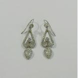 A pair of diamond drop earrings with pear-shaped diamond drops,