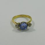 A sapphire and diamond three-stone ring, London 1991, the oval mixed cut sapphire approximately 3.