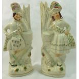 A pair of Victorian Staffordshire pottery flatback figures of a Scottish couple each with a drum,