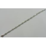 A diamond line bracelet the 13 elliptical links interspersed with individual diamond set links,