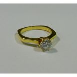 A yellow metal six sided diamond single stone ring, the round brilliant cut diamond approximately 0.