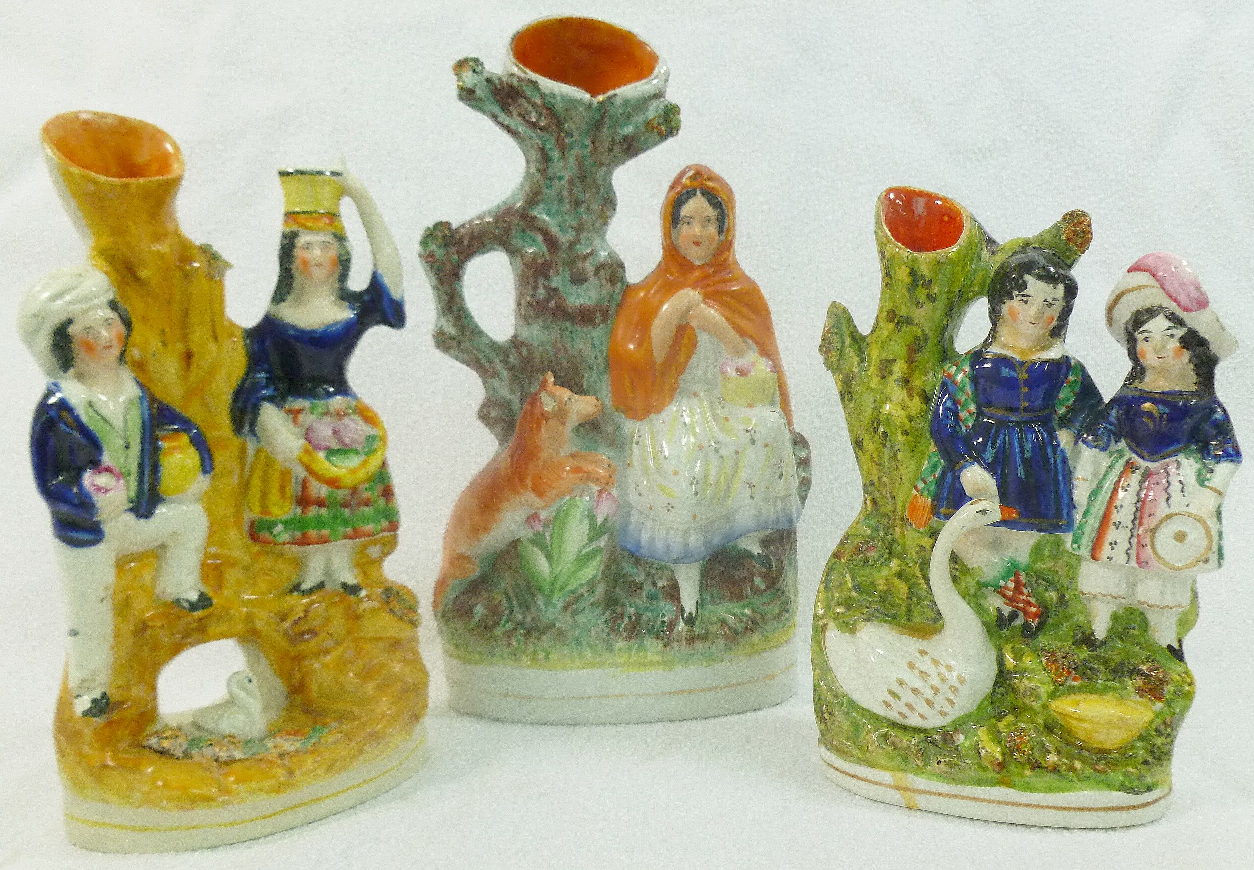 Three Staffordshire pottery flatback figural spill vases, two portraying a couple with a swan, 20.
