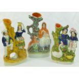 Three Staffordshire pottery flatback figural spill vases, two portraying a couple with a swan, 20.