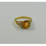 A yellow sapphire and diamond ring, the oval mixed cut sapphire approximately 1.