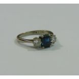 A sapphire and diamond three stone ring, the central emerald cut sapphire approximately 1 carat,