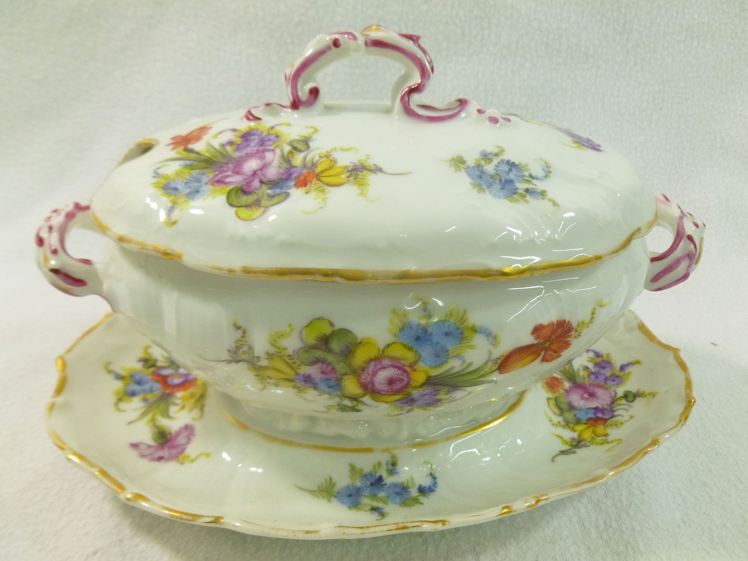 A 19th century Meissen porcelain oval sauce tureen with integral stand, with gilt rims,