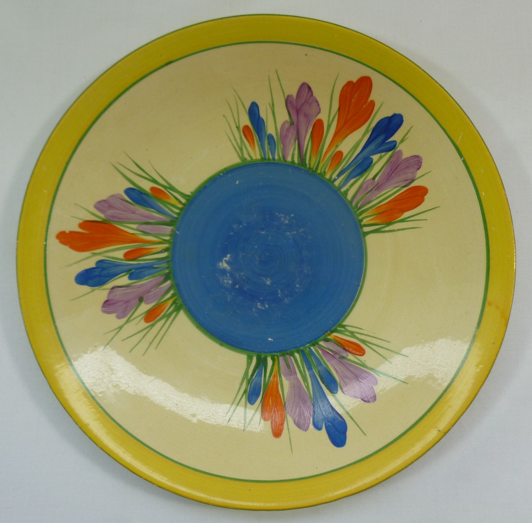 A Clarice Cliff Newport Pottery Bizarre Ware Crocus pattern plate, with blue centre and yellow rim,