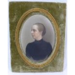 A late Victorian oval portrait miniature on porcelain of a woman, in a black dress,