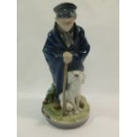 A Royal Copenhagen porcelain figure of a boy and his dog,