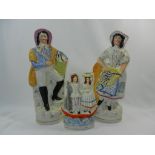 A large pair of Staffordshire figures of a fisherman and fisherwoman and a smaller group of a