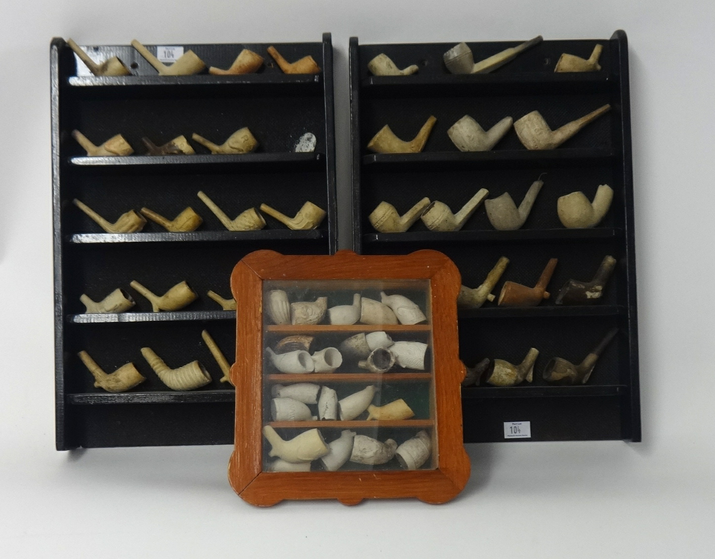 Collection of approx. 59 clay pipe bowls and display racks.