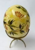 Painted Ostrich egg on brass stand.