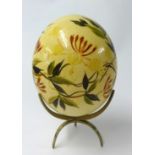 Painted Ostrich egg on brass stand.