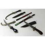 Collection of six daggers including Middle Eastern curved blade and white metal daggers also Far