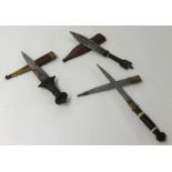 Three interesting Eastern daggers with scabbards, longest 33cm.