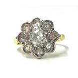 An 18ct gold and diamond cluster ring set with old cut stones, the central claw set stone bordered