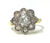 An 18ct gold and diamond cluster ring set with old cut stones, the central claw set stone bordered
