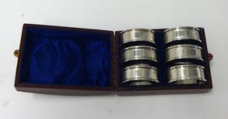 A set of six silver napkin rings in fitted case, weight 62.60g.