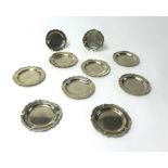 A set of eight metal petal dishes stamped 0900 and two similar smaller examples weight 28oz.